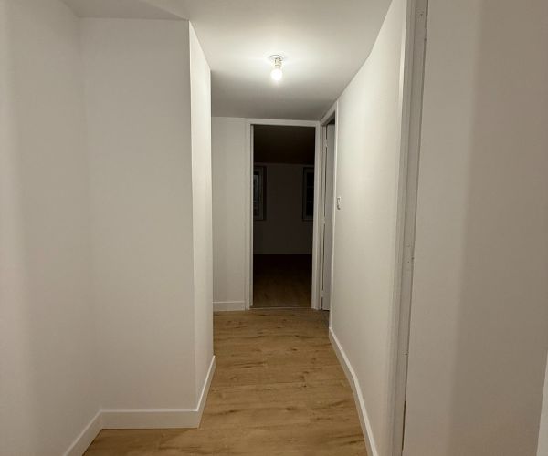 Palier rénové avec sol imitation bois et murs blancs