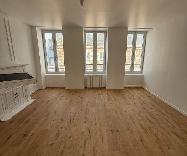 Salon rénové avec parquet clair et murs blancs